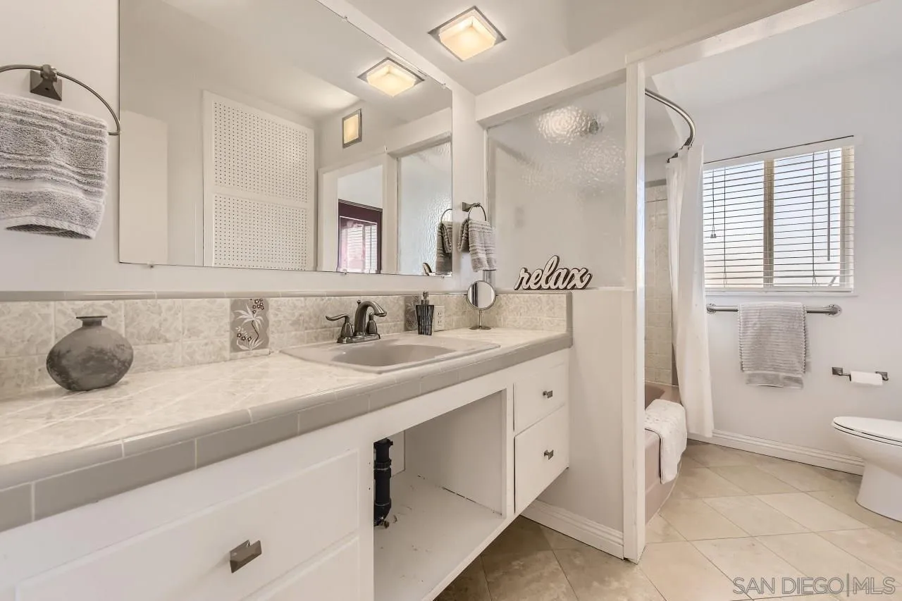10158 Madrid Way Spring Valley, CA 91977 - Photo 18 of 27 a bathroom with a granite countertop sink and a mirror