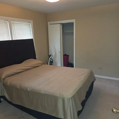 a bed sitting in a bedroom next to a window