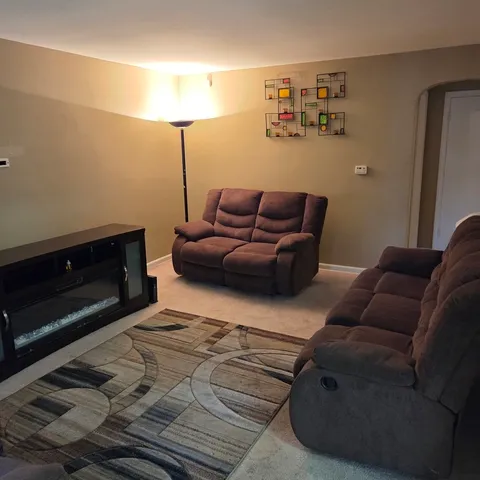 a living room with a couch and a lamp on a rug