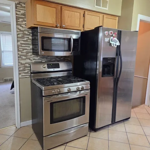 a kitchen with granite countertop a refrigerator and a stove
