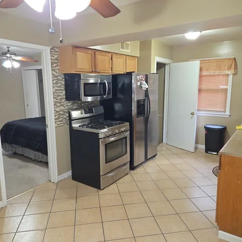a kitchen with stainless steel appliances granite countertop a refrigerator and a stove top oven