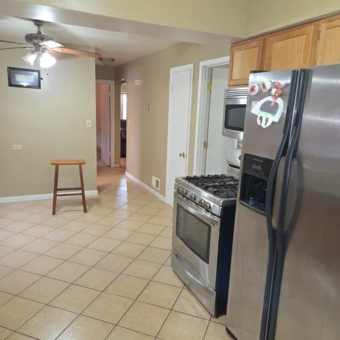 a kitchen with stainless steel appliances granite countertop a refrigerator and a stove