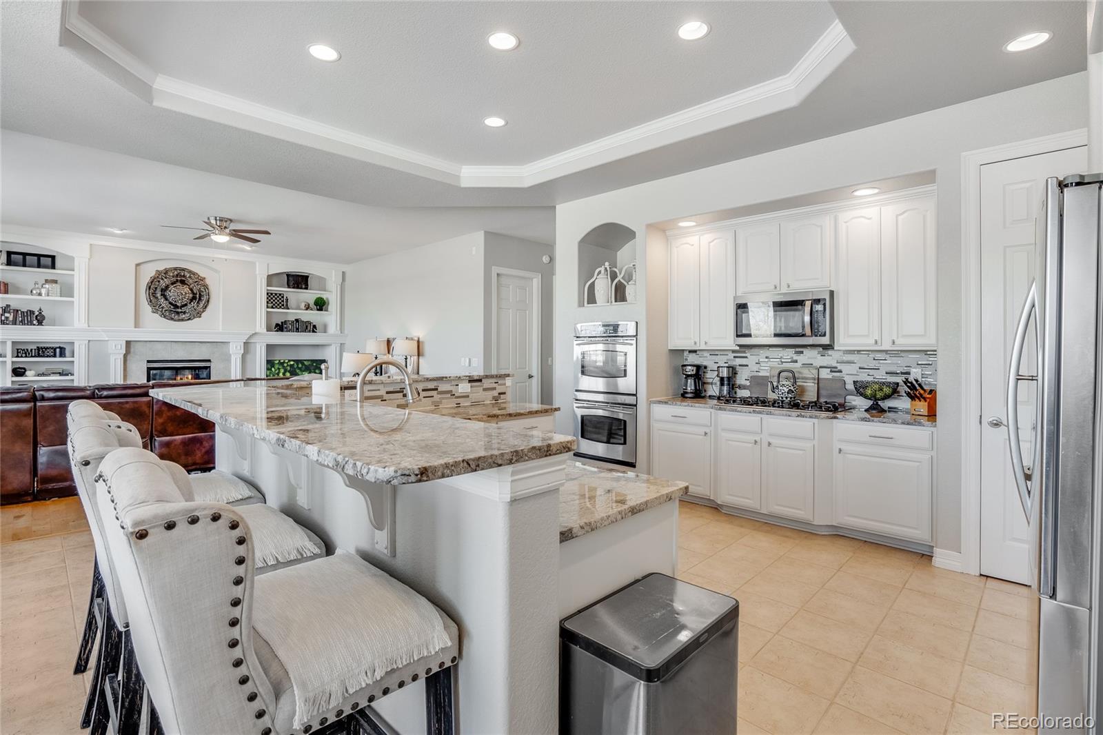 7285 Sagebrush Drive Parker, CO 80138 - Photo 16 of 46 a open kitchen with stainless steel appliances kitchen island granite countertop a sink and cabinets