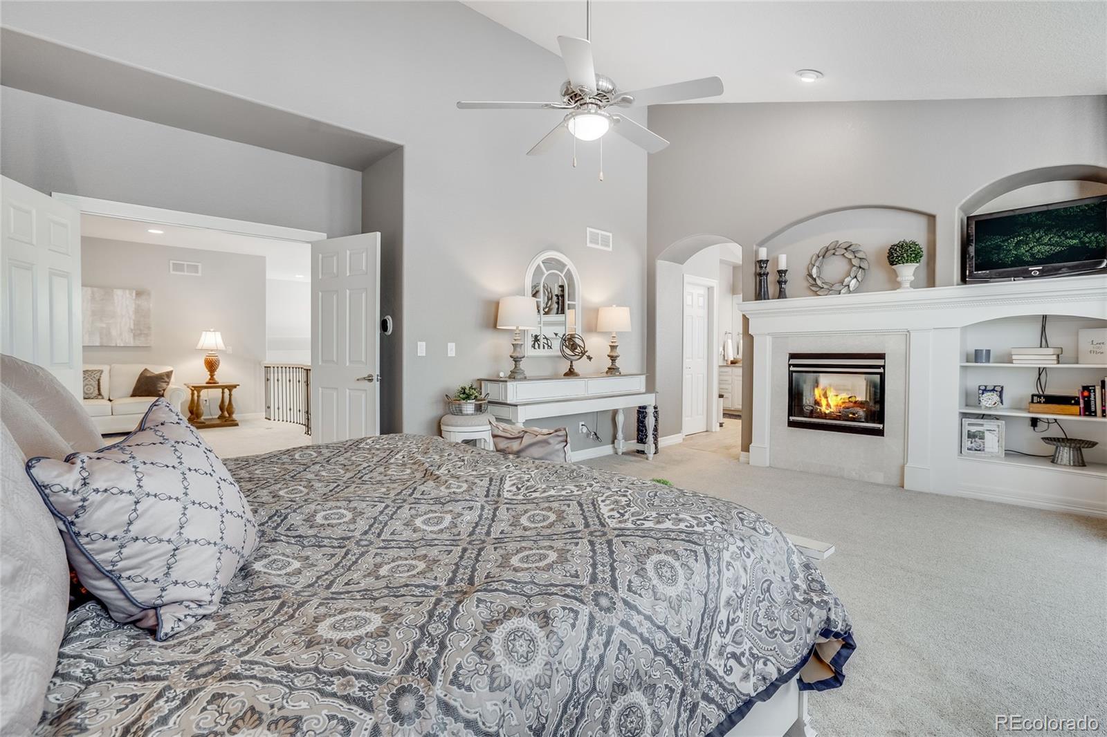 7285 Sagebrush Drive Parker, CO 80138 - Photo 24 of 46 a bedroom with a bed and a fireplace with chair