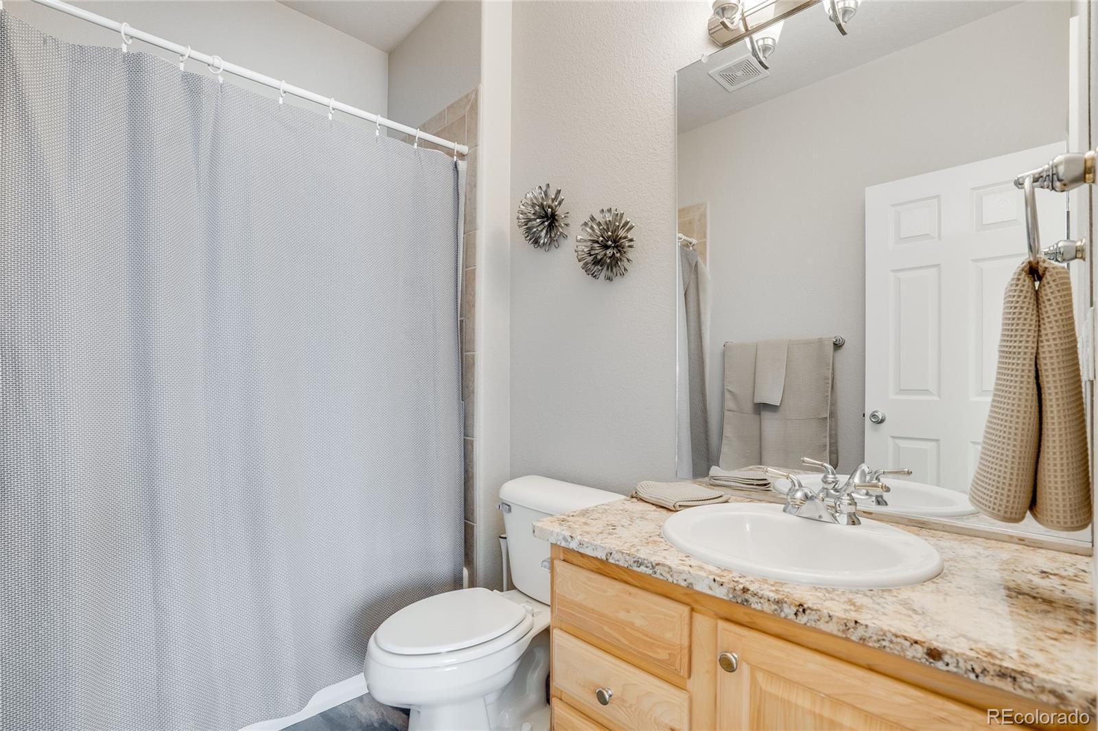 7285 Sagebrush Drive Parker, CO 80138 - Photo 30 of 46 a bathroom with a granite countertop sink toilet and a mirror