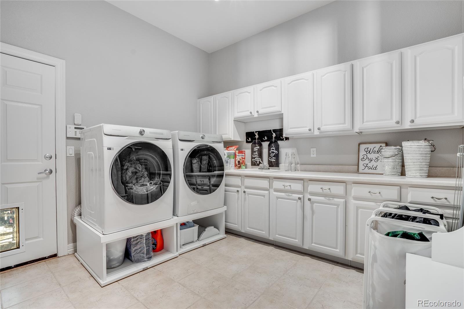 7285 Sagebrush Drive Parker, CO 80138 - Photo 33 of 46 a utility room with sink dryer and washer