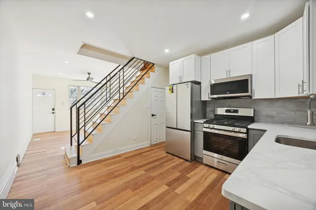 a kitchen with granite countertop a stove and a microwave