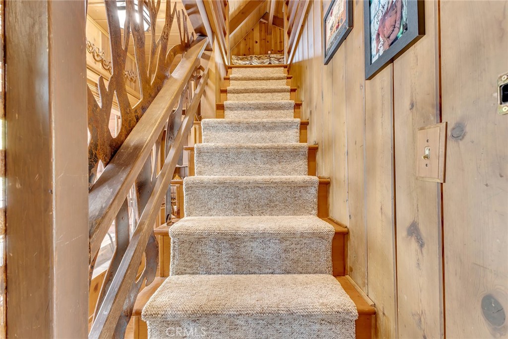 25300 Pine Crest Avenue Idyllwild, CA 92549 - Photo 33 of 75 Stairs leading to leading to loft with 3 built-in beds, one queen sized bed, and sitting area with electric fstove/fireplace.