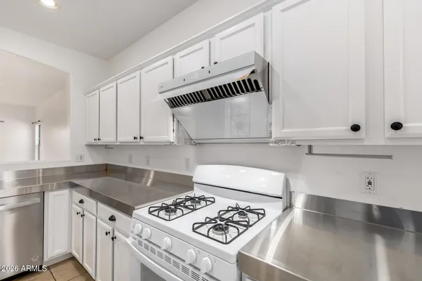 a kitchen with a stove and white cabinets