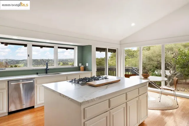 a kitchen with a large window and a view of living room