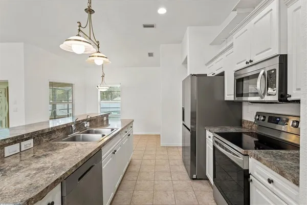 a bathroom with a granite countertop double vanity and a mirror