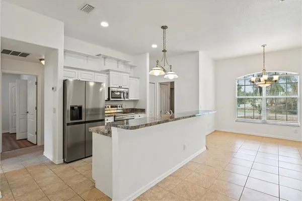 a kitchen with stainless steel appliances granite countertop a sink a refrigerator and a granite counter tops
