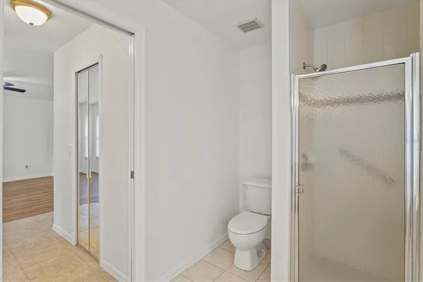 an empty room with wooden floor and ceiling fan