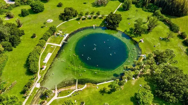 an aerial view of a house with a garden and lake view