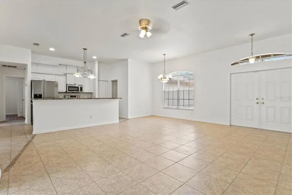 a view of a kitchen with kitchen island white cabinets and refrigerator