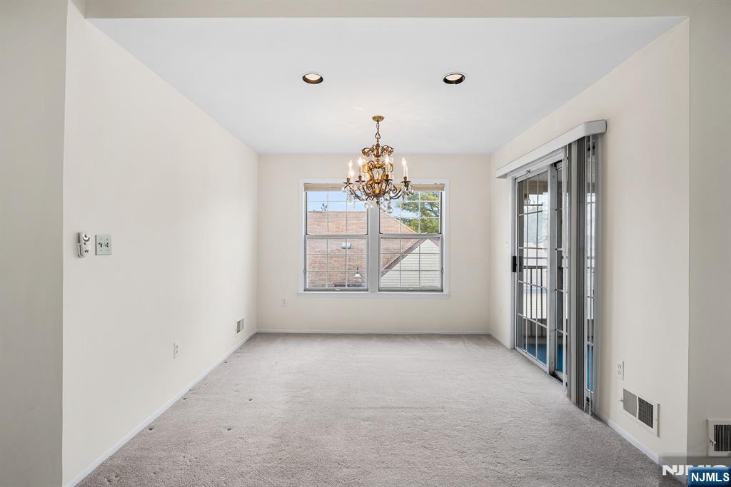 11A Rothwell Drive, Unit 11D Monroe Township, NJ 08831 - Photo 14 of 47 an empty room with windows and chandelier