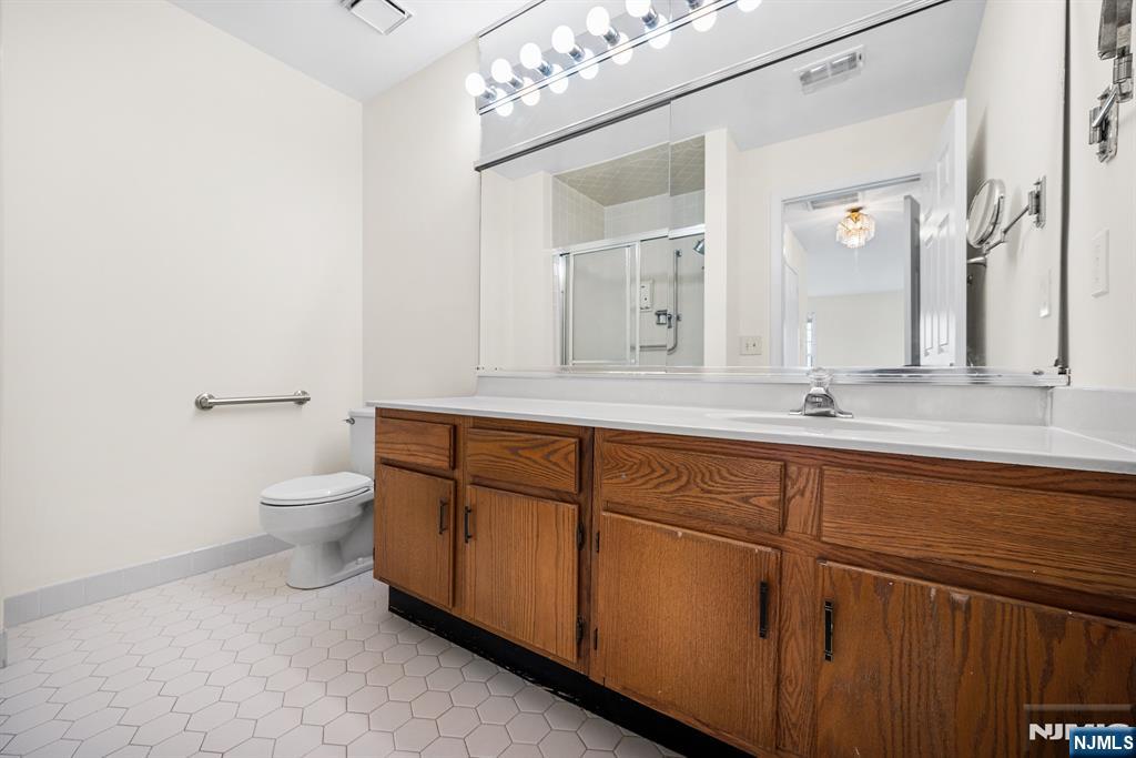 11A Rothwell Drive, Unit 11D Monroe Township, NJ 08831 - Photo 22 of 47 a bathroom with a granite countertop toilet sink and mirror