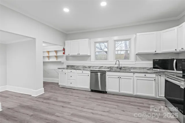 a kitchen with granite countertop white cabinets and white appliances