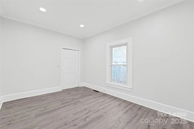 an empty room with wooden floor and window