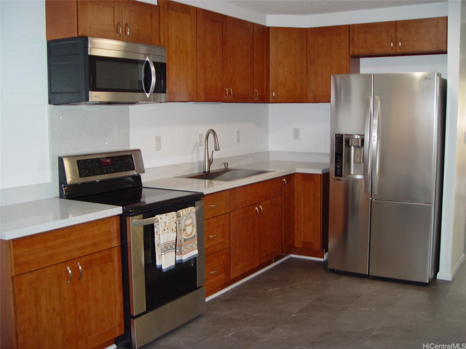 a kitchen with stainless steel appliances granite countertop a refrigerator a sink a stove and microwave