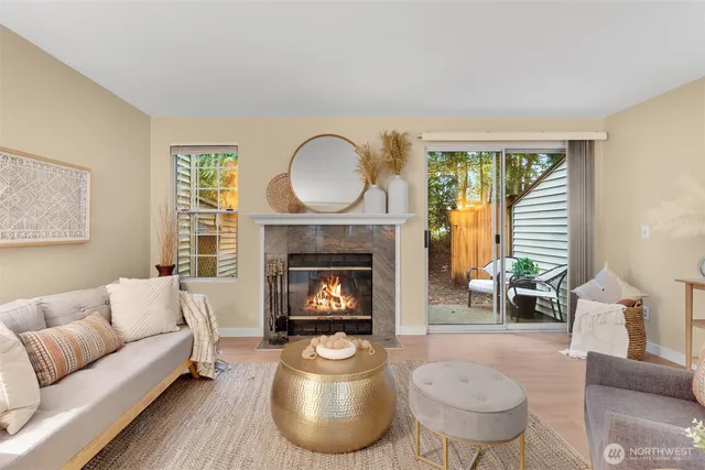 a living room with furniture a fireplace a lamp and a large window