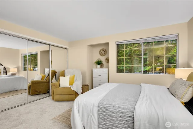 a spacious bedroom with a bed and glass window
