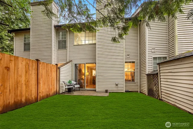 a view of a backyard with plants and wooden fence