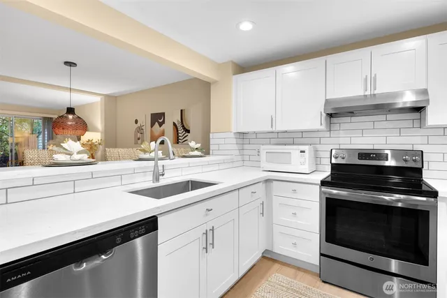 a kitchen with white cabinets and appliances