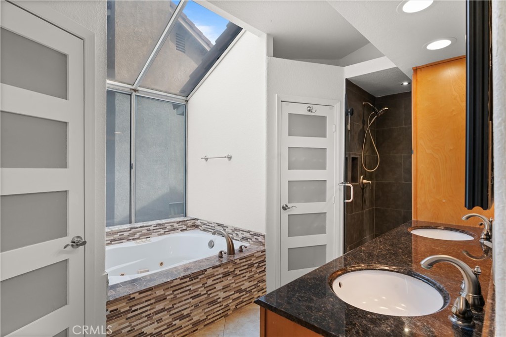 3371 Amy Drive Corona, CA 92882 - Photo 29 of 44 a bathroom with a granite countertop sink a mirror and a bathtub