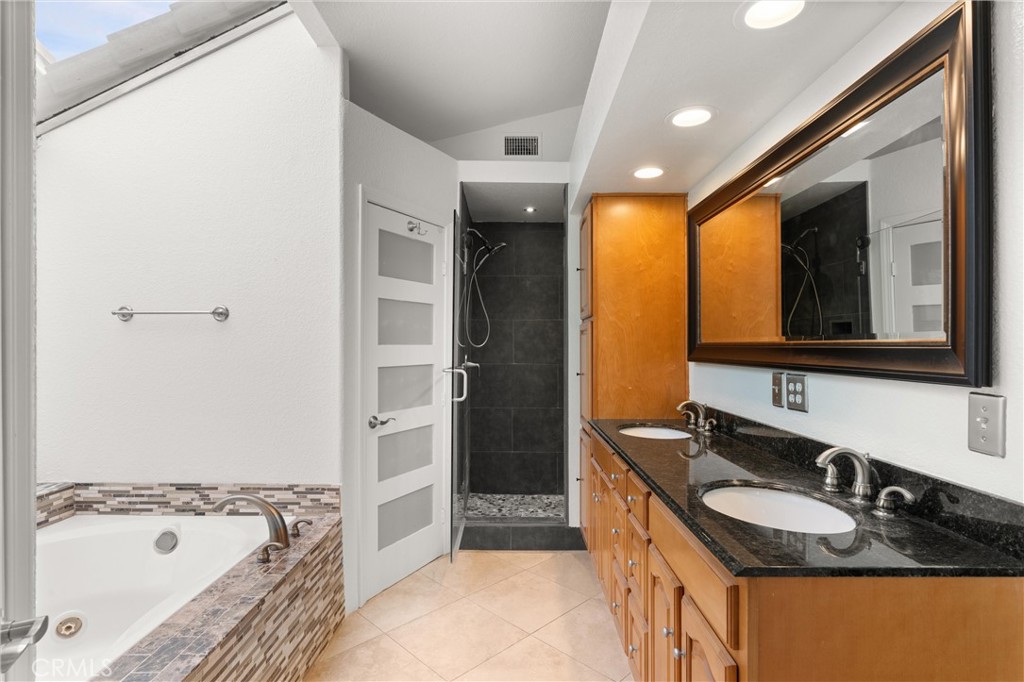 3371 Amy Drive Corona, CA 92882 - Photo 30 of 44 a bathroom with a granite countertop tub sink and mirror