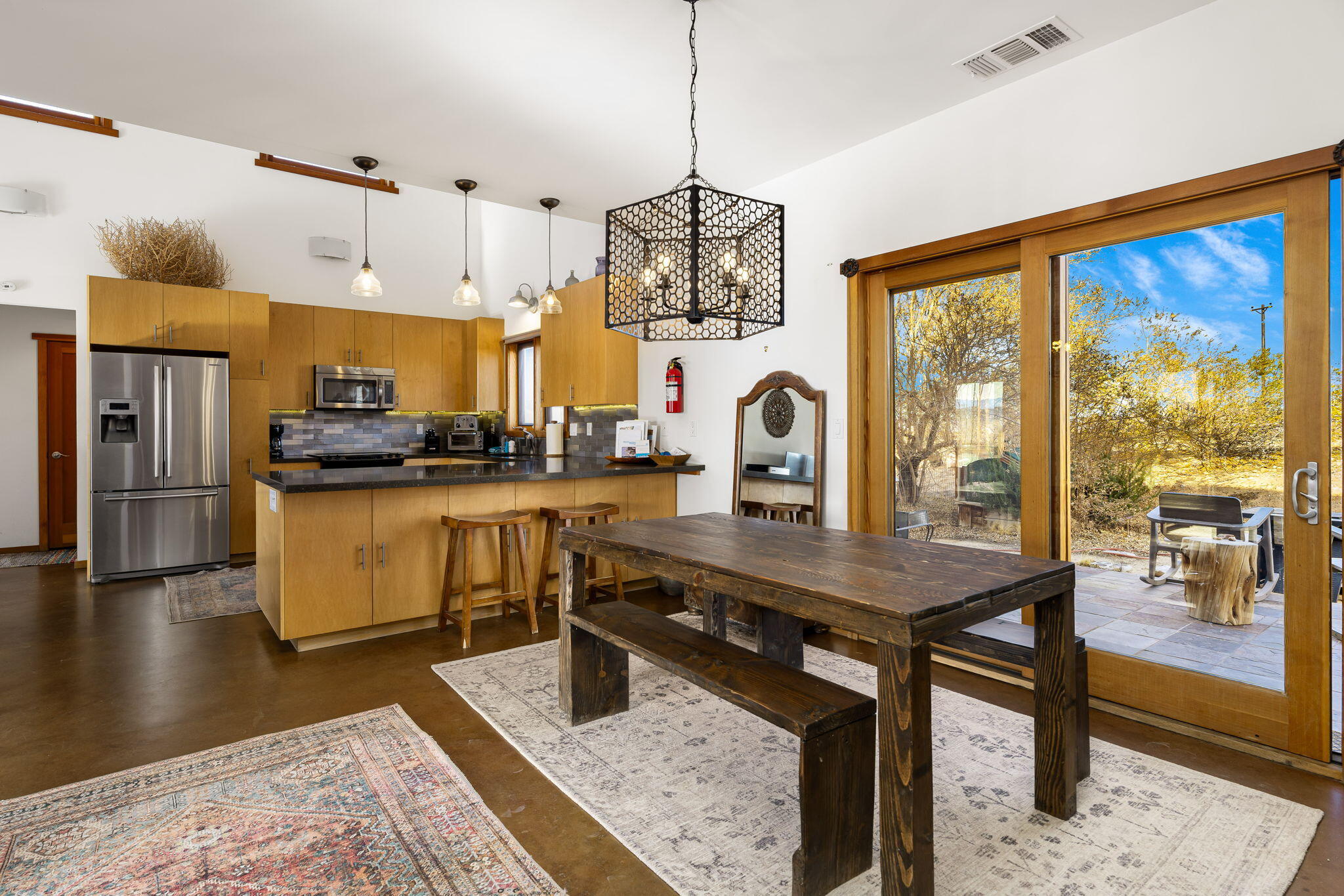 1776 Sunview Avenue Joshua Tree, CA 92252 - Photo 18 of 55 a kitchen with stainless steel appliances granite countertop a stove a refrigerator a sink dishwasher a dining table and chairs with wooden floor