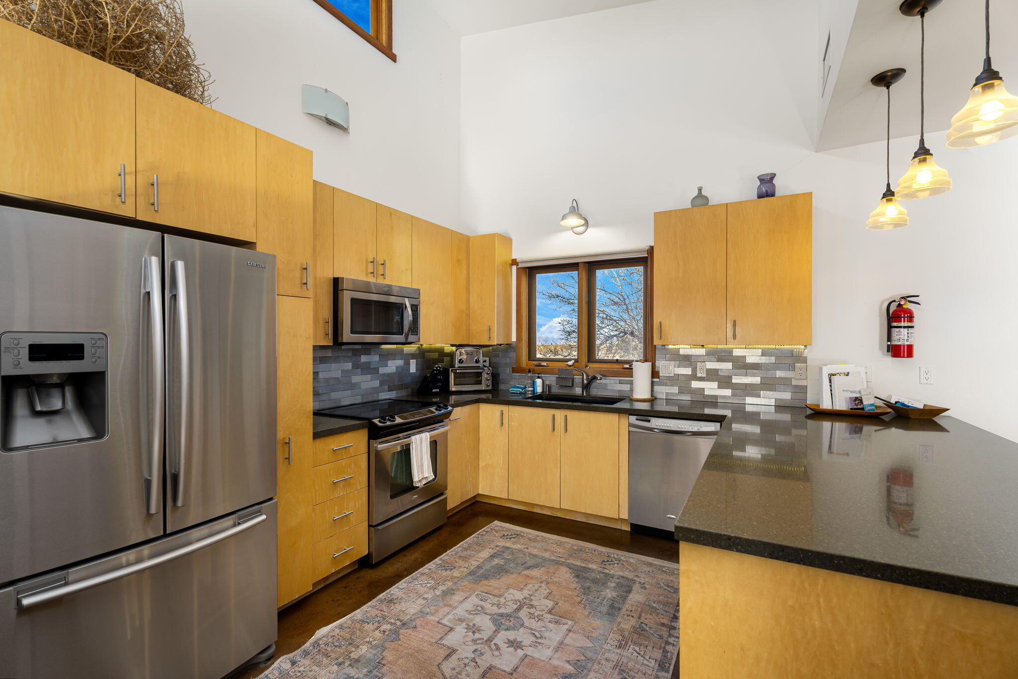 1776 Sunview Avenue Joshua Tree, CA 92252 - Photo 21 of 55 a kitchen with stainless steel appliances granite countertop a refrigerator a stove and a sink with wooden floor