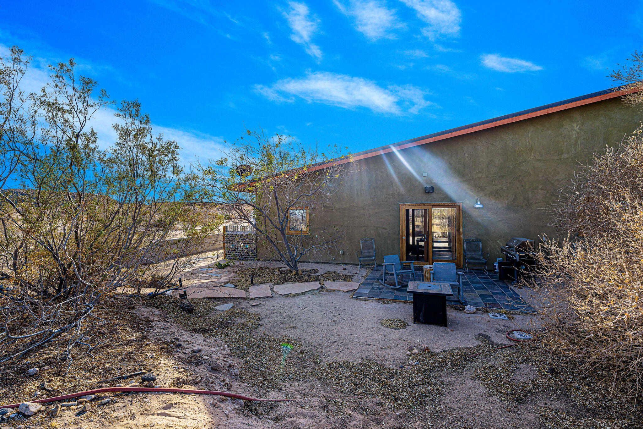 1776 Sunview Avenue Joshua Tree, CA 92252 - Photo 27 of 55 a backyard of a house with table and chairs