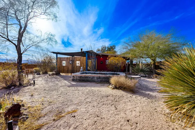 a view of a patio with table and chairs under an umbrella with wooden fence