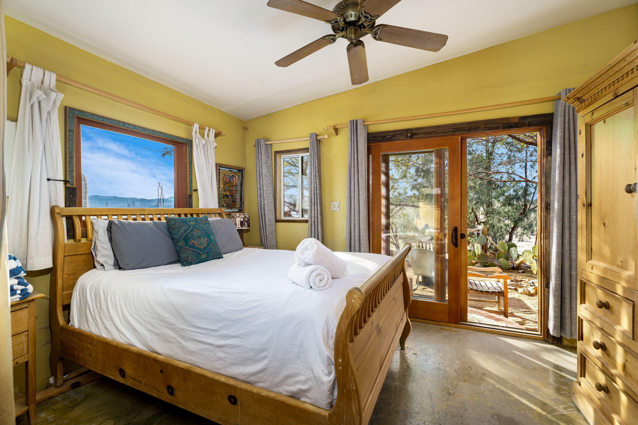1776 Sunview Avenue Joshua Tree, CA 92252 - Photo 47 of 55 a bedroom with a large bed and a chandelier