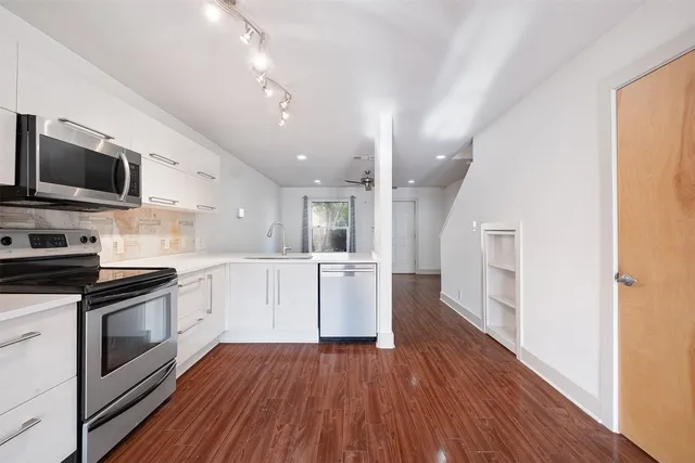 a kitchen with wooden floors and appliances