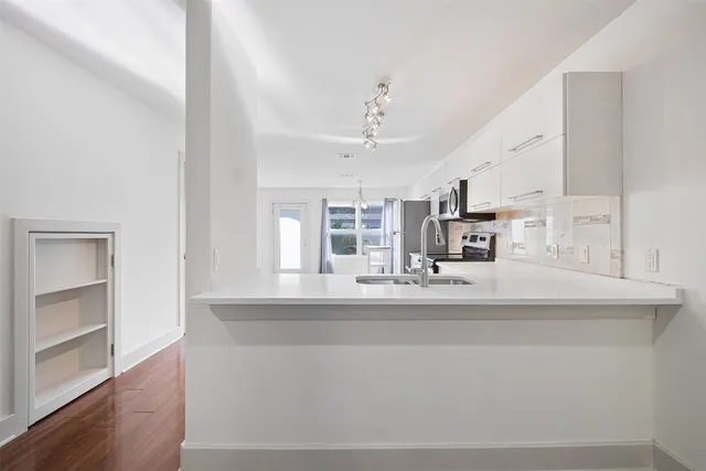 a kitchen with kitchen island a sink and wooden floor