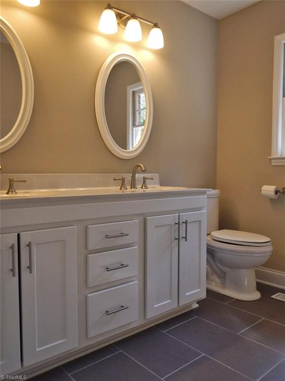 8007 Eastridge Road Oak Ridge, NC 27310 - Photo 17 of 29 The Master Bathroom has been updated with tile flooring & a comfort-level double vanity.
