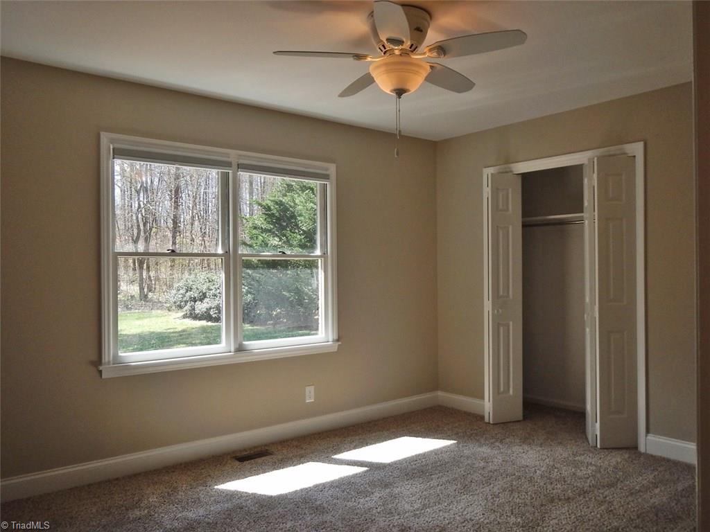 8007 Eastridge Road Oak Ridge, NC 27310 - Photo 19 of 29 The Second Bedroom has a ceiling fan & a double closet. Big windows overlook the back yard.