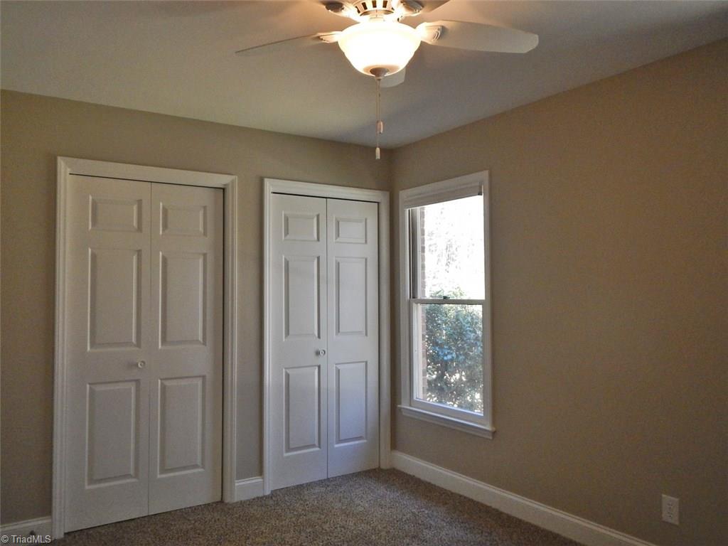 8007 Eastridge Road Oak Ridge, NC 27310 - Photo 21 of 29 The Third Bedroom has two closets, two bright windows & a ceiling fan as well.