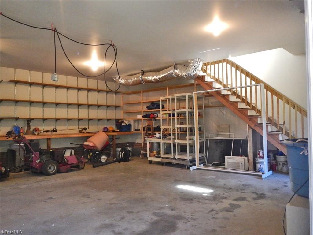 8007 Eastridge Road Oak Ridge, NC 27310 - Photo 26 of 29 The garage has plenty of room for two large cars & there is an abundance of shelving & work-tops.