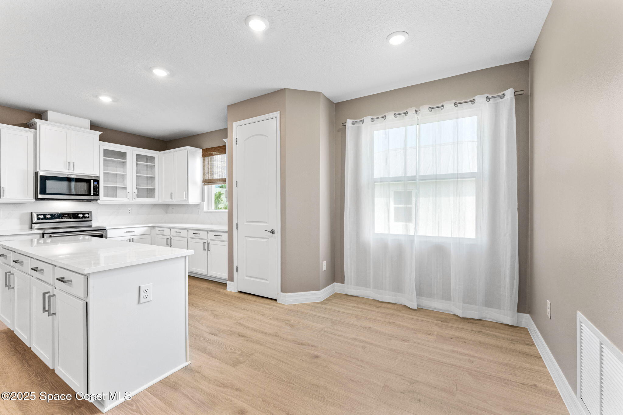 225 1st Street Cocoa, FL 32922 - Photo 39 of 64 a kitchen with stainless steel appliances granite countertop a stove a sink and a refrigerator with wooden floor