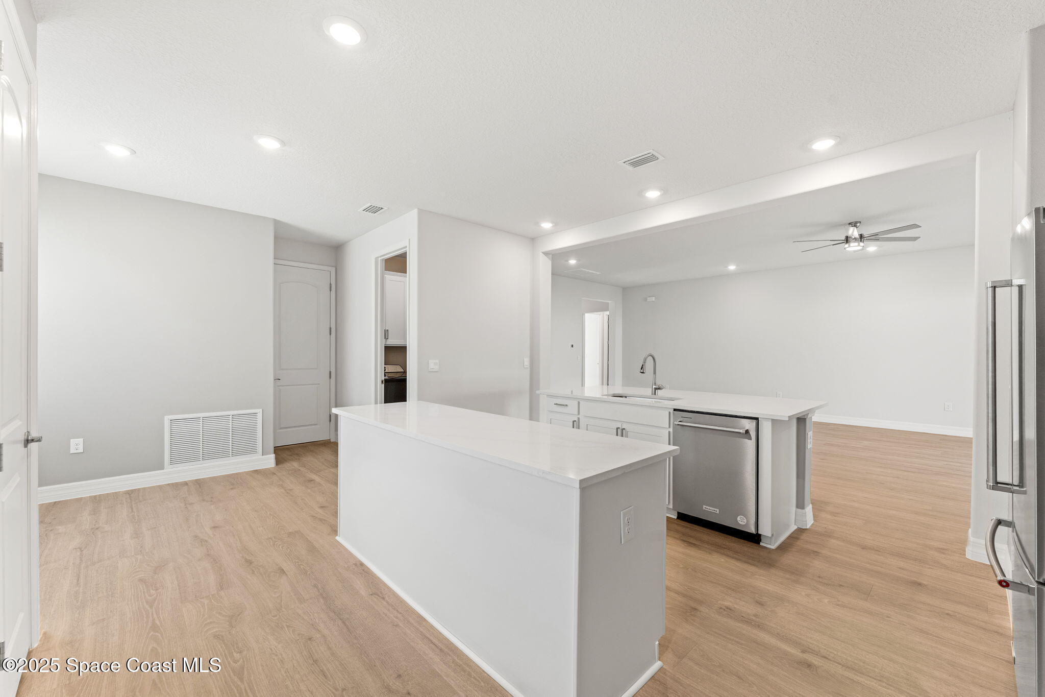 225 1st Street Cocoa, FL 32922 - Photo 41 of 64 a large white kitchen with wooden floor and stainless steel appliances