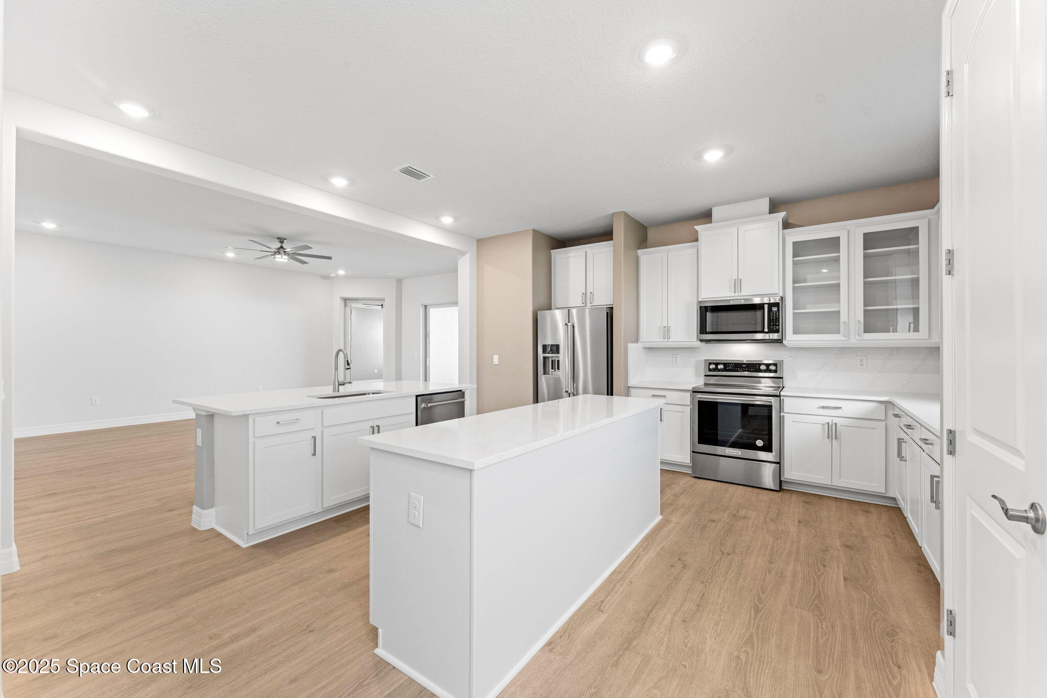 225 1st Street Cocoa, FL 32922 - Photo 46 of 64 a large kitchen with kitchen island a sink a stove a refrigerator and white cabinets