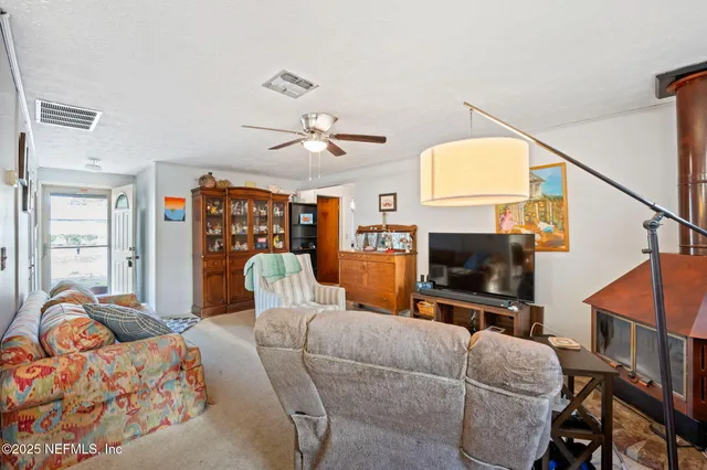 a living room with furniture a flat screen tv and a window