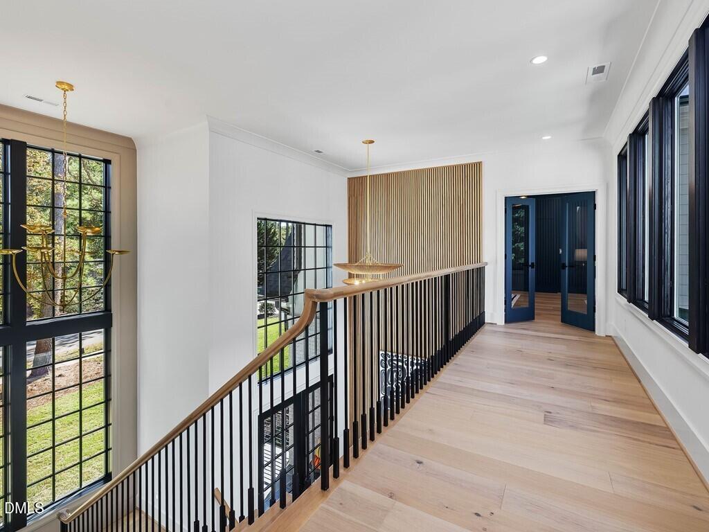 7013 Buckhead Drive Raleigh, NC 27615 - Photo 42 of 80 a view of a hallway with wooden floor and windows