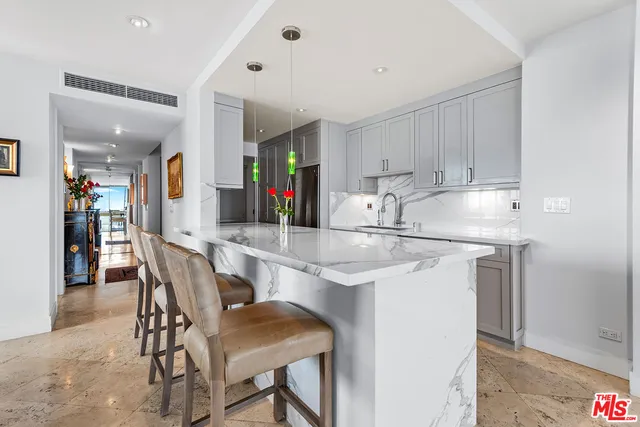a kitchen with stainless steel appliances granite countertop a table chairs sink and cabinets