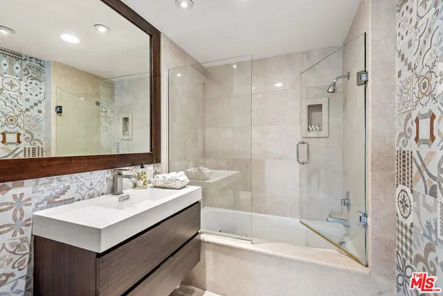 a bathroom with a sink double vanity mirror and a bathtub