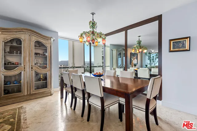 a dining room with furniture a chandelier and wooden floor