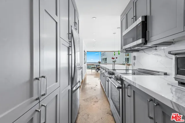 a kitchen with stainless steel appliances granite countertop a sink a stove and a refrigerator
